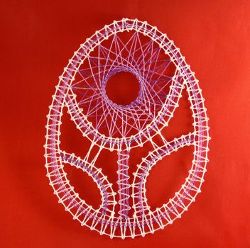 Easter egg hand made bobbin lace on red background