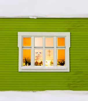 Beautiful window on a wood house with christmas decorations
