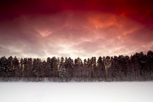 Landscape picture of a frozen lake on a beautiful day with a red sunset
