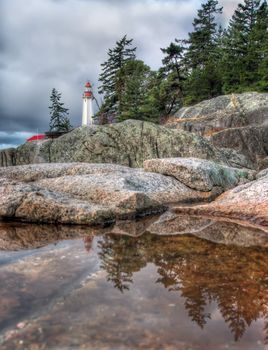 Lighthouse reflection in small tidal pool in lighthouse park West Vancouver