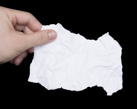 Hand holding crumpled torn paper note isolated on black