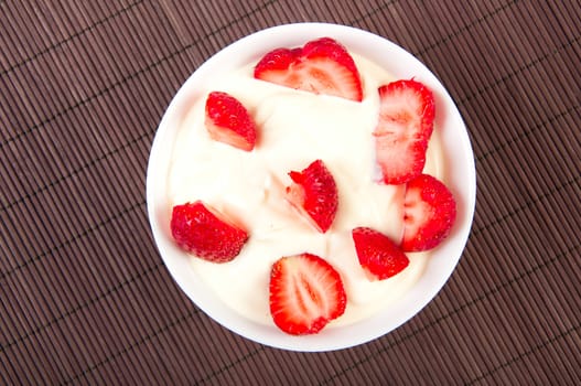 strawberries, with cream on bamboo tablecloth, still life