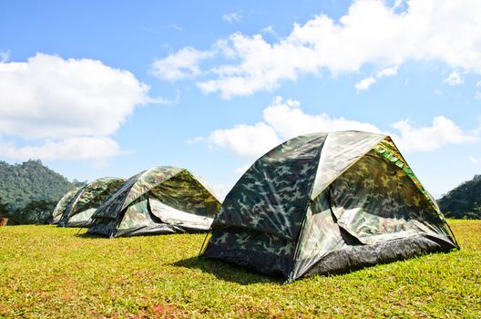 Tent on a grass under white clouds and blue sky