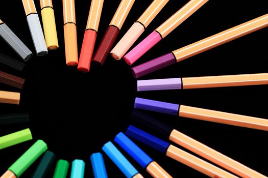 Color Pens in form of love on black background