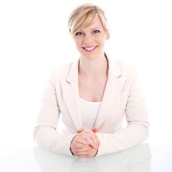 High key portrait of a beautiful blonde businesswoman with a lovely smile sitting at a desk looking at the camera