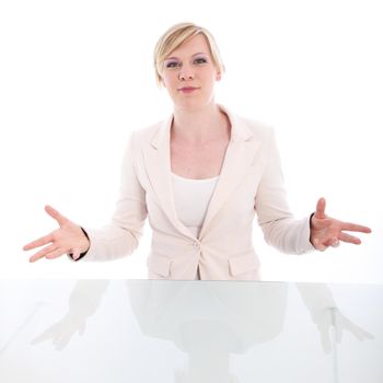 Eloquent young woman standing behind a reflective table pleading her case accompanied with expressive hand gestures on a white studio background