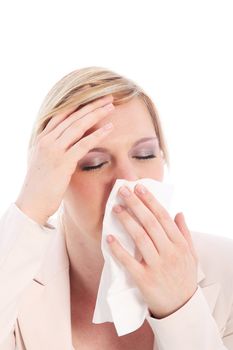 Ill woman with a fever and chills suffering from seasonal influenza holding her hand to her forehead as she holds up a hanky to stop her running nose
