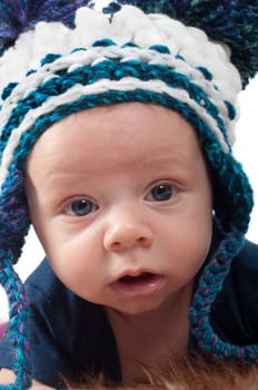 Cute baby in knitted hat watching on you