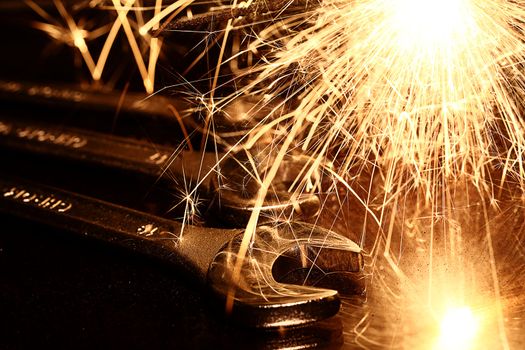 Closeup of iron spanners set and sparks light