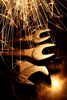 Closeup of iron spanners set and sparks light