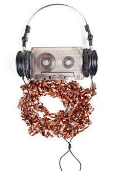 Headphones on audio cassette with pulled out tape