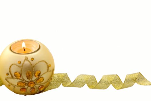 Candle with Christmas decorations and a golden ribbon at the bottom, on white background
