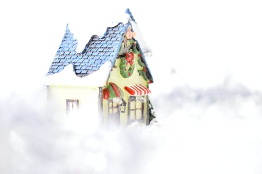 decorative house in artificial snow on white background