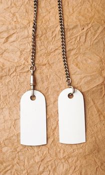 blank tags with silver chain on vintage background. space for your text