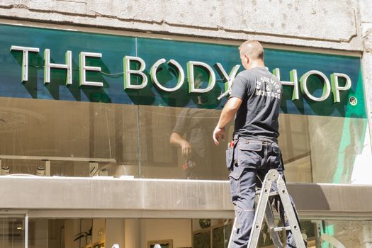 Copenhagen.Denmark -August 2012. The worker installs outdoor advertizing of cosmetic shop.