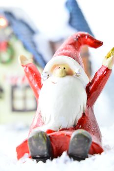 decorative Santa Clause in front of a house on white background