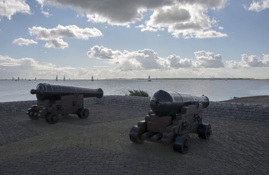twocannon in the hrabor with boats on th background
