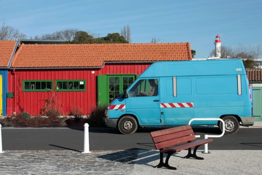 blue car with red island house and bench on ile d'Oleron, France