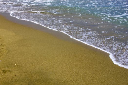 Gentle waves reach the sand at coast