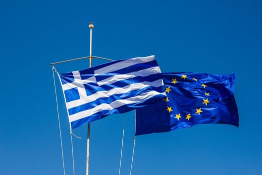 Greek and EU Flags versus the blue sky