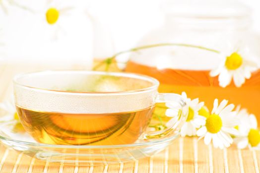 A teacup and a teapot with herbal chamomile tea