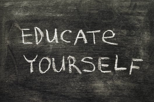 educate yourself phrase handwritten on school blackboard