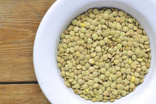raw dry lentil beans in white bowl ; focus on lentil
