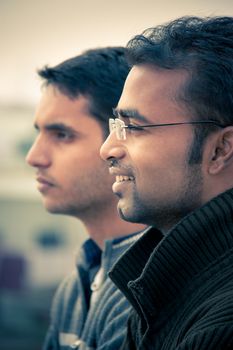 Two indian happy handsome men looking at something and both are smiling.