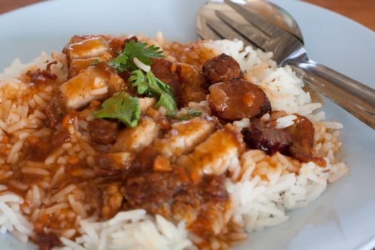 Rick with pork crispy and sausage served with red soup.