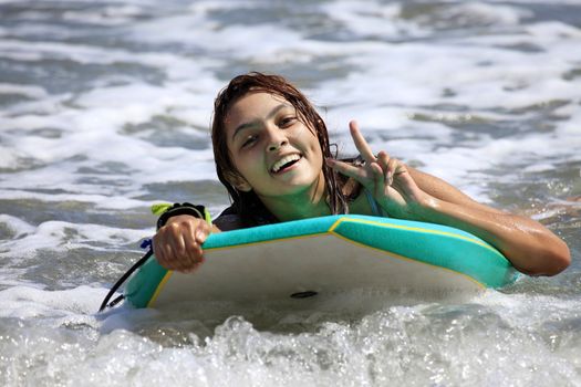 The young girl - surfer in ocean. Bali. Indonesia