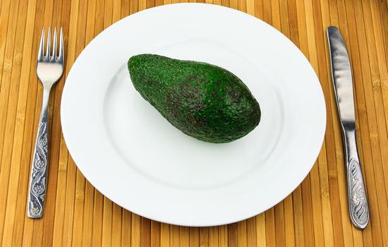 avocado on a plate with cutlery