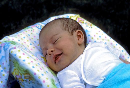 Newborn baby smiling in his sleep.