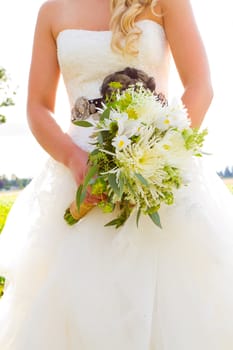 A beautiful bride holds her wedding bouquet before her ceremony with a stylish wedding photography abstract feel.