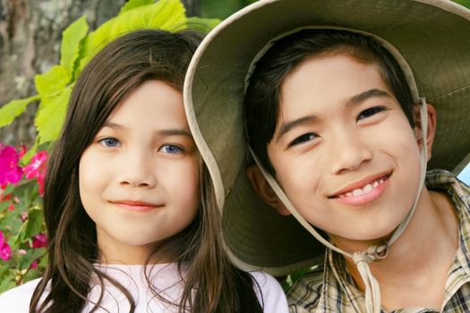 Brother and sister smiling outdoors in summer