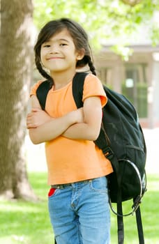 Cute biracial five year old with backpack at school