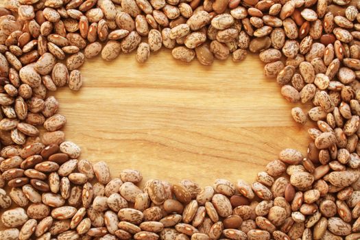 A close-up background or wallpaper image of heirloom dry Pinto beans on a wooden background