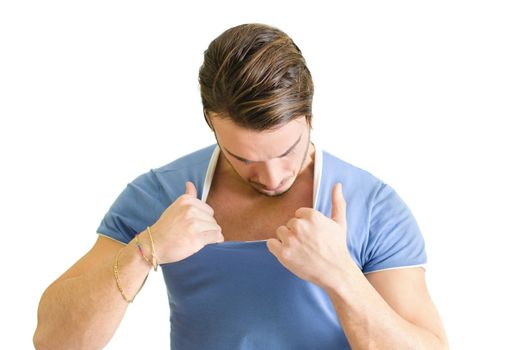 Athletic guy looking inside his shirt, checking out his muscles