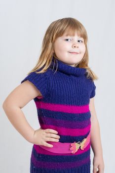 portrait of an little blonde girl wearing a purple and pink dress
