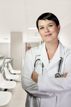 Young doctor in white uniform. Woman with lab coat and stethoscope in a business environment