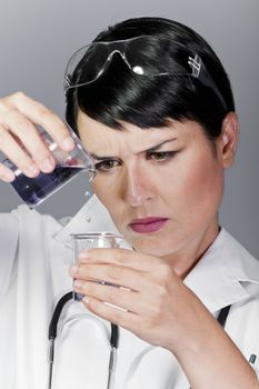 black substance being dropped from pipette into tube with water, laboratory tests