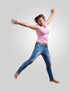 pretty modern slim hip-hop style woman jumping dancing on a colour background