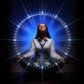 Young businesswoman sitting against blue background with clock interface