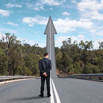 Concept of the road to success with a businessman standing on the road