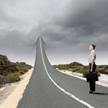 Concept of the road to success with a businesswoman standing on the road