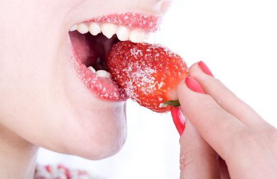 Girl biting a juicy strawberries in sugar