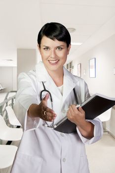 Young doctor in white uniform, Portrait of happy smiling female with clipboard at office