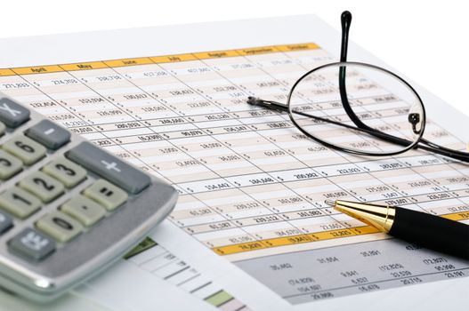 Financial forms with pen, calculator and glass.