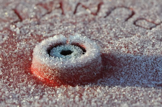 Close-up of White Frost on a Red Piece of Metal