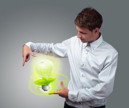 Young businessman holding virtual eco sign