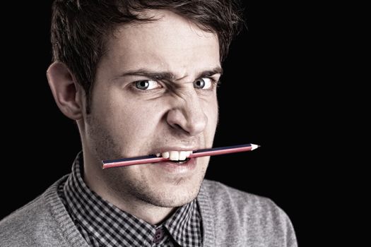portrait of a young angry man with pencil 